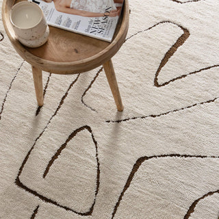 Mila Modern Lines Cream and Brown Rug in a cosy living room setting