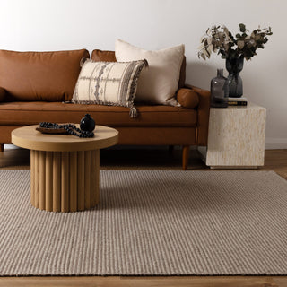 Natura Oatmeal Wool Rug in living room with brown leather sofa