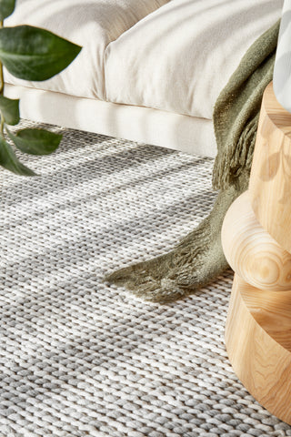 Close-up of Carina Grey & Ivory Braided Wool Rug - Natural wool and viscose with rustic braided texture